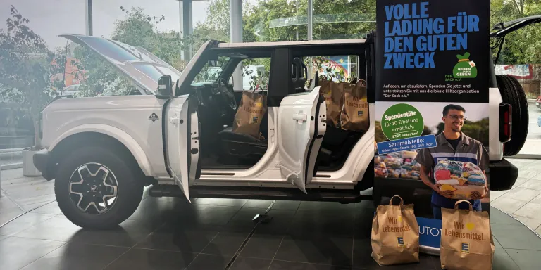  Ford SUV mit vielen Lebensmittel-Spendentüten im Vordergrund